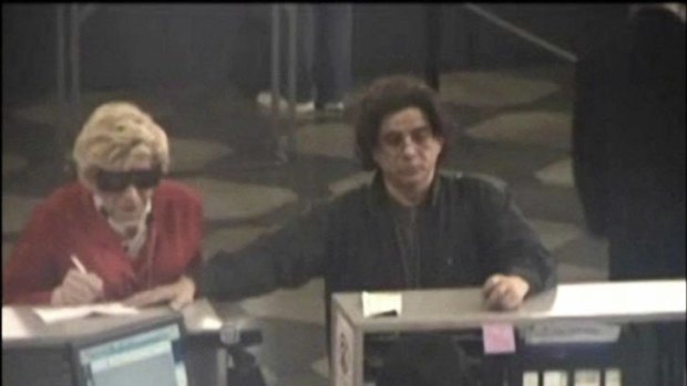 This May 2009 photo from video shows, according to prosecutors, Thomas Parkin, 49, at left, on a Department of Motor Vehicles security camera, dressed up as his mother, who died in 2003, as part of a scam to collect her government benefits. At right is Mhilton Rimolo, a friend of Parkin's who authorities say acted as an accomplice in the scheme.