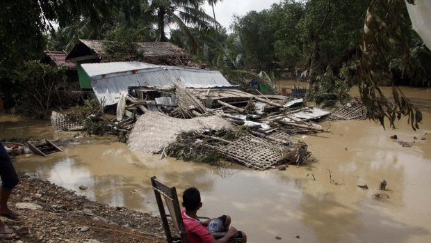 A local resident sitting on a chair looks at his damaged residence in Myauk U, Myanmar on Tuesday.
