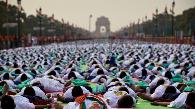 Indian Prime Minister Narednra Modi, center front, lies down on a mat as he performs yoga along with thousands of Indians on Rajpath, in New Delhi, India, Sunday, June 21, 2015. Millions of yoga enthusiasts are bending their bodies in complex postures across India as they take part in a mass yoga program to mark the first International Yoga Day.