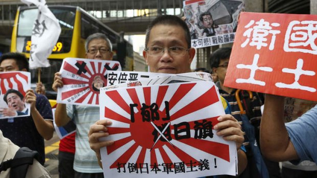 Anti-Japan protesters demonstrate with Japanese military flags with Chinese words, " Down with Japan militarism "  in Hong Kong.