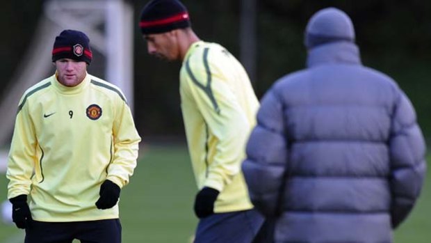 Chilly day ... Wayne Rooney and Rio Ferdinand train under the watchful eye of  Manchester United manager Alex Ferguson.