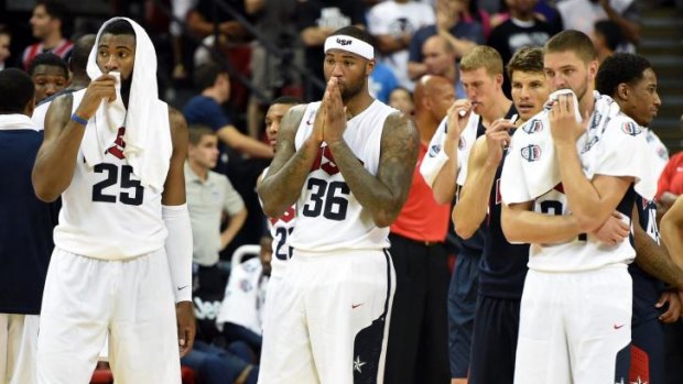 Thoughts with their fallen teammate: Members of Team USA watch on as Paul George receives medical attention.