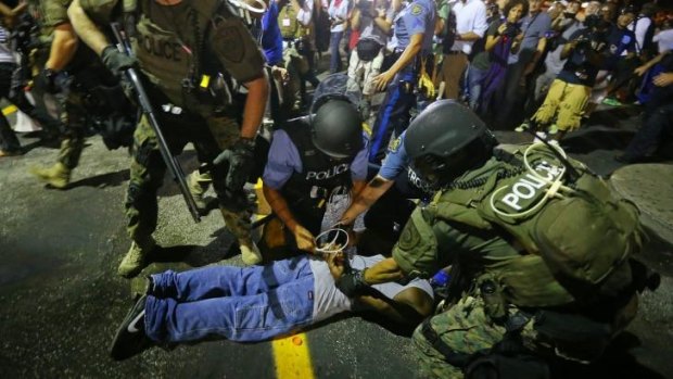 Baghdad or Missouri?: Khaki-clad police officers apprehend a man in Ferguson during this week's protests.