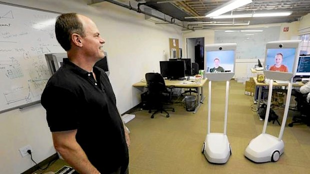 Bo Preising, Suitable Technologies' vice president of engineering, at left, talks with fellow engineers, Josh Faust, center on screen, and Josh Tyler, on screen at right, both using a Beam remote presence system in Palo Alto, California.