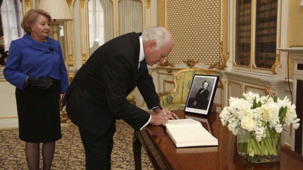 "Courage and resilience" ... John and Janette Howard sign a book of condolence for Margaret Thatcher at Lancaster House.