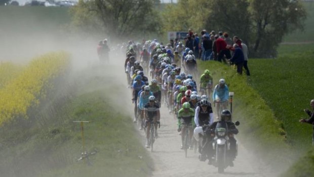 Riders pedal through a cobblestoned section during the 112th edition of the Paris-Roubaix one-day classic.
