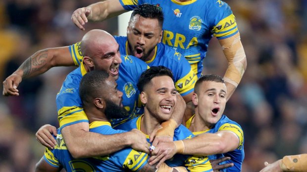 Happy bunch: Corey Norman, centre, celebrates with teammates after a try against the Broncos.