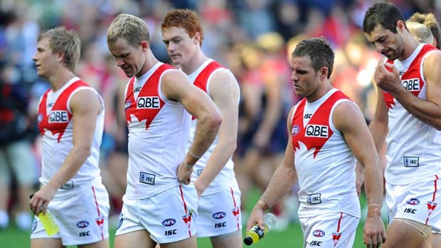 Disappointed . . . the Swans trudge off after drawing with Melbourne.