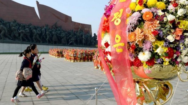 Tribute: North Koreans offer flowers as they visit the statues of  late leaders Kim Il-sung and Kim Jong-il in Pyongyang.