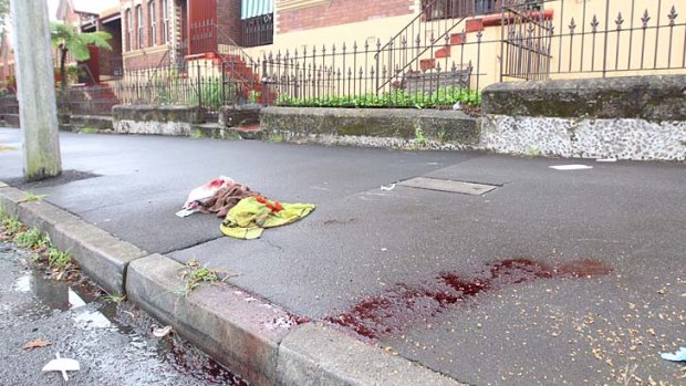Blood stains and towels on the pavement in Jones Street, Pyrmont, where a man and his son were shot on Sunday.