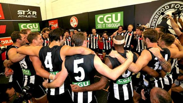 The Magpies belt out their song in the rooms following their win against Essendon.