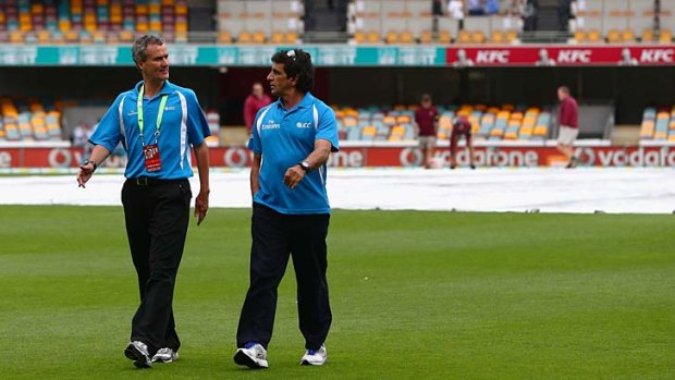 Umpires Billy Bowden and Asad Rauf leave the field after inspecting the pitch before abandoning play without a ball being bowled on day two of the first Test.
