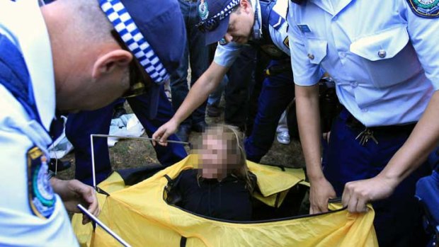 An Occupy Sydney protestor is removed by police while sitting in a tent.