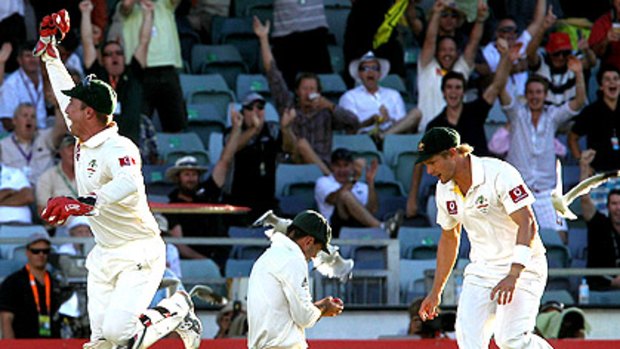 Australian wicketkeeper Brad Haddin (left) celebrates his rebound catch to dismiss Jonathan Trott, while Ricky Ponting inspects his injured finger.