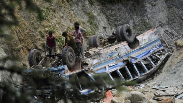Kashmiri villagers inspect the wreckage of a bus which plunged into a gorge in Nambal Nard, on July 11, 2012. 44 people are missing after the latest incident.