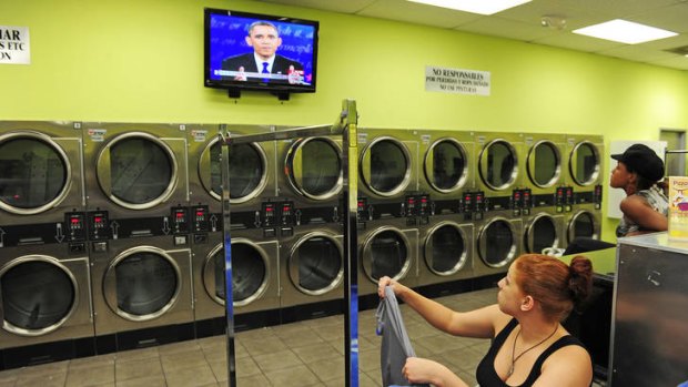 Two women watch the presidential debate at a laundromat in Los Angeles, California.
