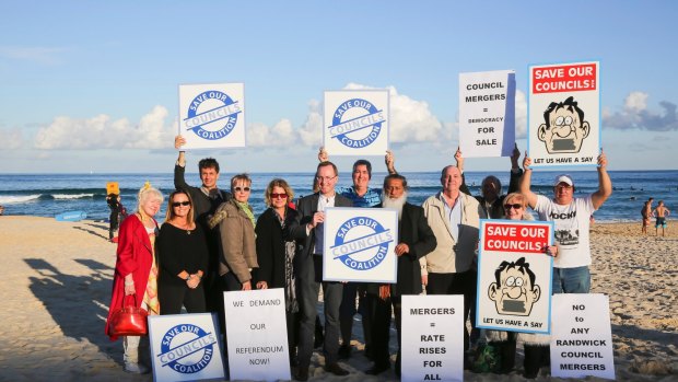 Greens MP David Shoebridge with residents and councillors, holding up rally signs on Bondi beach after the Keep it Local Forum at Bondi Pavilion on June 14.