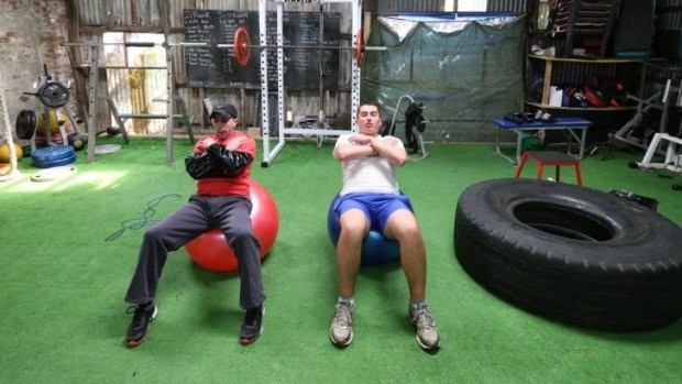 Burden to bear: Brenton Avdulla (red shirt) and Adam Pengilly work out at a Randwick gym this week.
