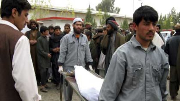 Hospital workers carry the body of a man killed in a blast in Lashkar Gah, southern Afghanistan.