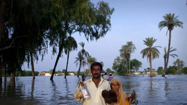 A couple wades through floodwaters in Punjab province. <i>Picture: Reuters</i>