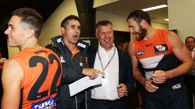 One more time: Giants coach Leon Cameron (left) and departing football manager Graeme Allan join players for the club song after the win against Hawthorn.