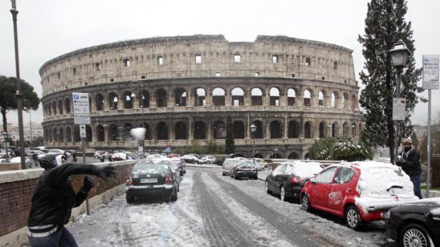 Boys throw snowballs in front of the Colosseum in Rome.