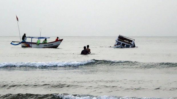 Rescuers approach the capsized boat off the coast of Pangandaran in West Java.