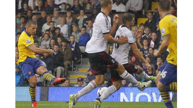 Lukas Podolski scores his second goal against Fulham on Saturday.