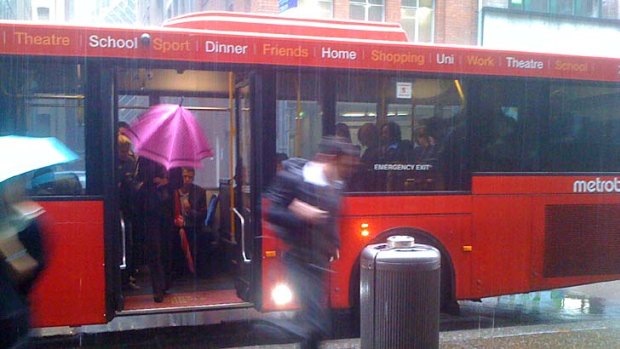 Commuters dash for cover as the rain lashes down in the CBD today.