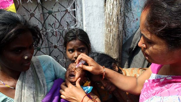 Better safe than sorry ... a vaccinator squirts two drops of the polio vaccine into the mouth of Krishna, four months, in the arms of his mother, Devi.