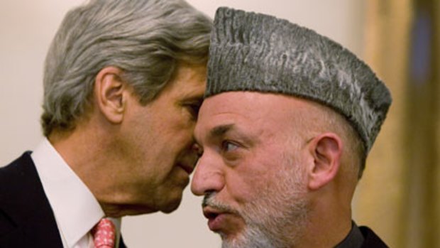 Second poll ... US senator John Kerry whispers to Hamid Karzai. They had negotiated the decision over five days.