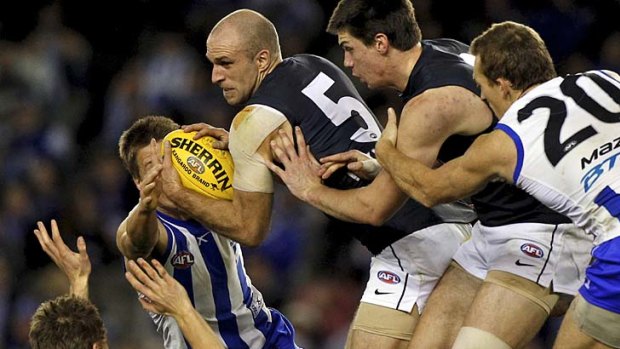 Bullocking Blue: Chris Judd, with some help from Matthew Kreuzer, forces a path between a mob of Kangaroos.