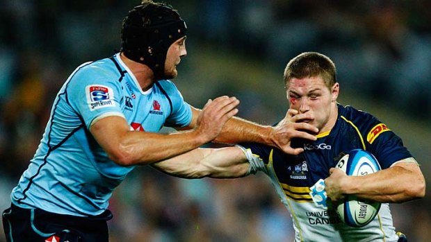 Changing of the guard ... Michael Hooper, fending off Dean Mumm, leaves the Brumbies for the Waratahs next season while Mumm is moving on.