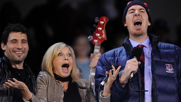 Playful ... Jim Stynes sings along with Olivia Newton John and  Russell Robertson before a Melbourne vs Carlton game in May last year.