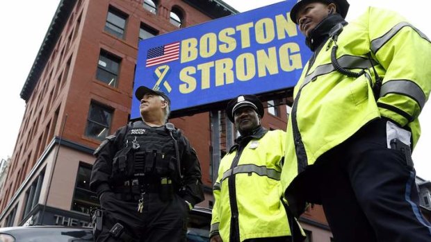 Boston Police stand near the site of one of the two bomb blasts on the one-year anniversary of the Boston Marathon bombings in Massachusetts.