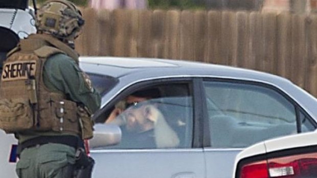 Law enforcement officers surround a shooting suspect in his car on Wednesday in Spring, Texas.