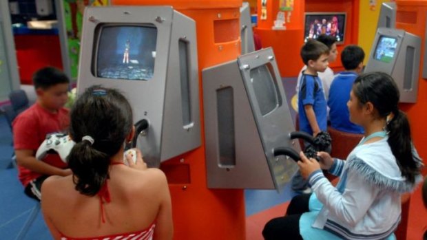 Cradle-to-the-grave: Children play with pokies-style machines in the creche at the Mounties Club in Mt Pritchard.