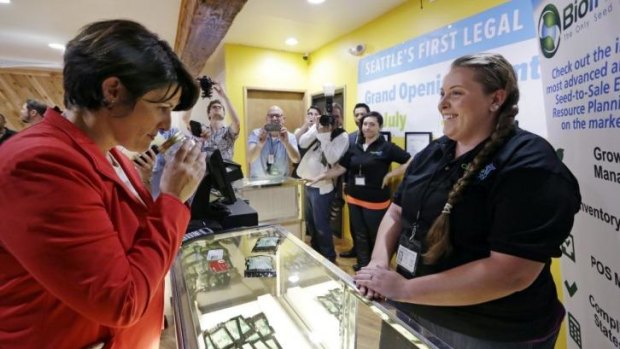 Alison Holcomb, criminal justice director at the Washington state branch of the American Civil Liberties Union, sniffs a sample of marijuana at Cannabis City in Seattle on Tuesday.