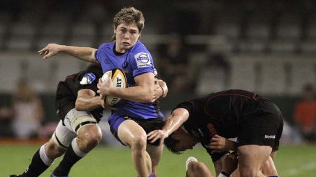 James O'Connor of the Western Force attempts to get out of the tackle of Steven Sykes of the Sharks.