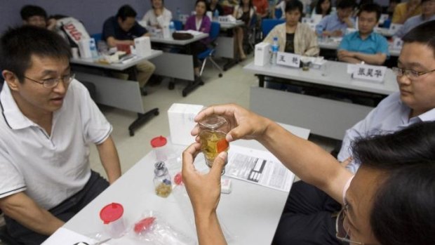 Chinese medical professionals practice urine collection procedures at a training class for the Beijing Olympic Games.