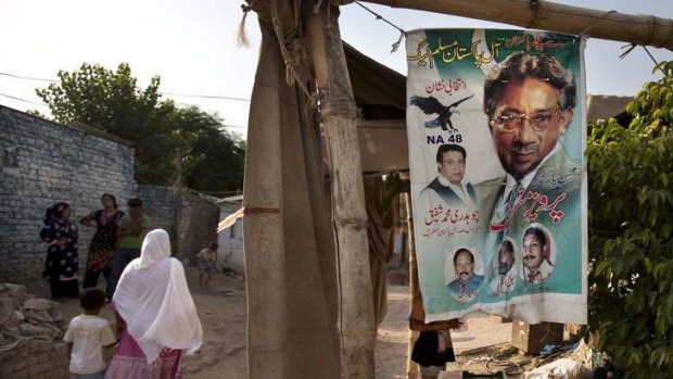 Signs of support: A Pakistani woman walks past an election banner for  Pervez Musharraf in a Christian neighbourhood of Islamabad.