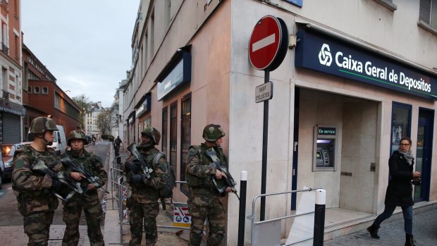 Military conduct patrols in Saint Denis as police conduct terror raids.