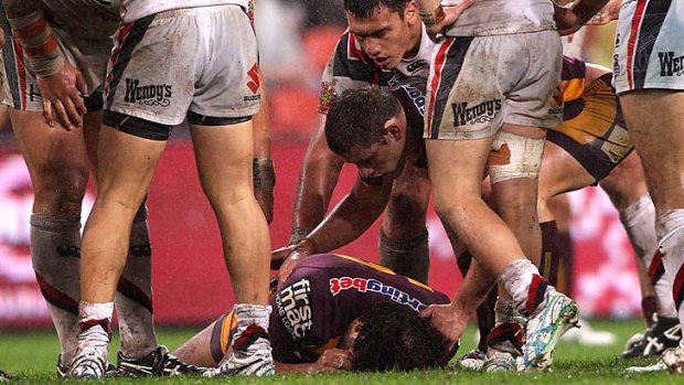 Worried Broncos team mates rush to aid captain Sam Thaiday who left the field after a heavy knock, but later returned to lead Brisbane to victory.