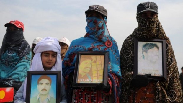 Baluch activists hold portraits of their missing loved ones on the way to Islamabad to protest their release by the Pakistani Government.