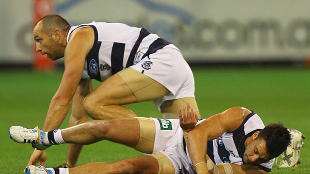Concussed: Geelong's Jimmy Bartel struggles to get up after colliding with teammate James Podsiadly.