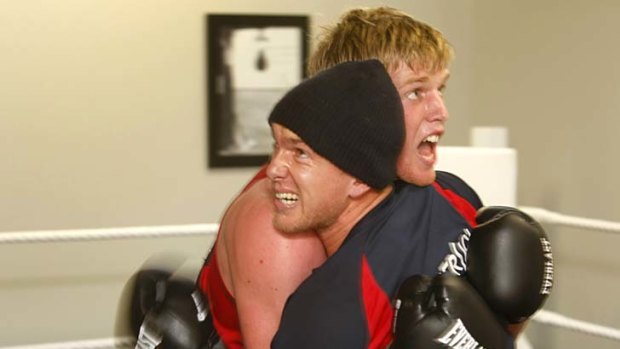 Hitout: Brent Moloney, in the beanie, grapples with teammate Troy Davis.