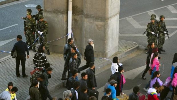 Chinese paramilitary policemen stand near the scene of an explosion outside a train station in Urumqi.