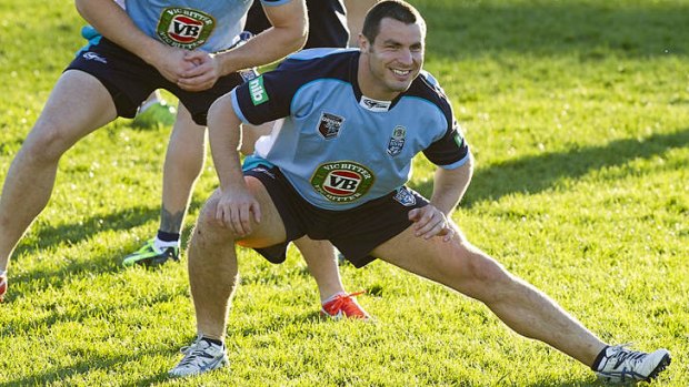 All smiles: NSW winger James McManus limbers up for training on Monday.