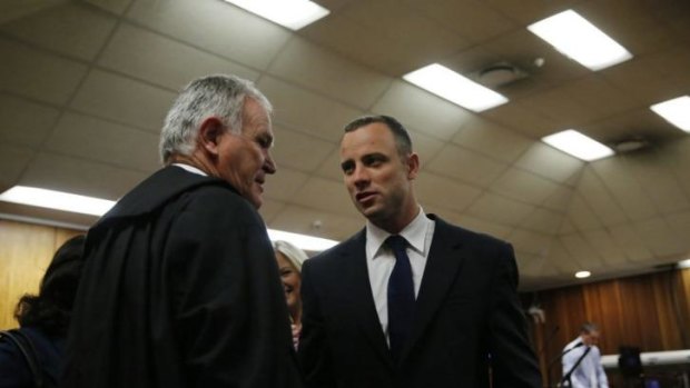 The case for the defence: Oscar Pistorius talks with his lawyer Barry Roux before Tuesday's hearing.