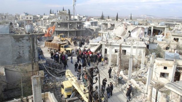 Wreckage: People gather around the site of a car bombing in Hama province.